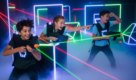 Kids playing laser tag in a glowing hallway