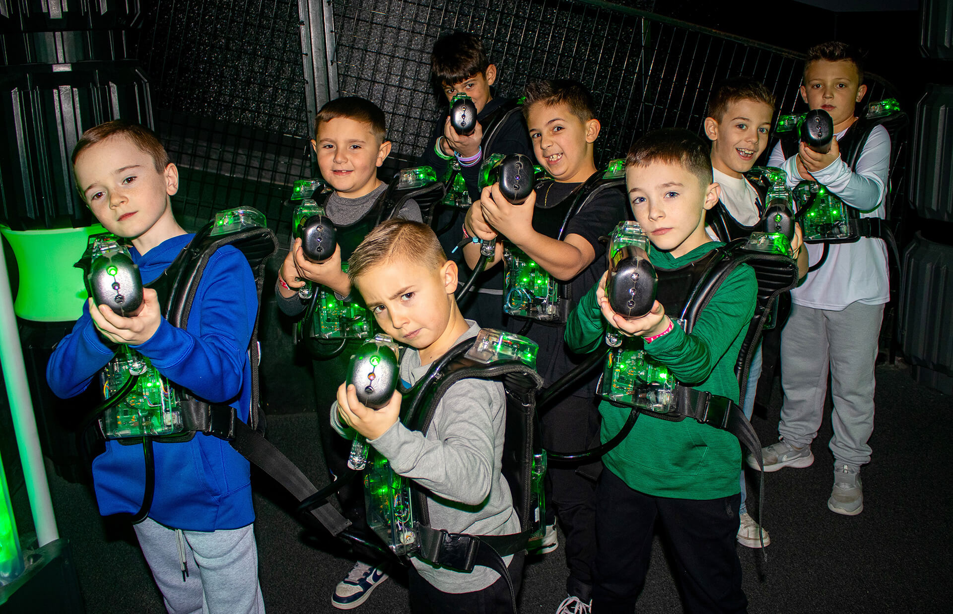 Group of kids smiling and posing with laser tag gear